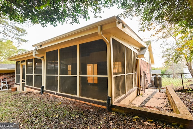 view of property exterior with a sunroom and central AC