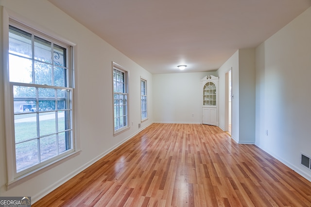 unfurnished room with plenty of natural light and light hardwood / wood-style floors