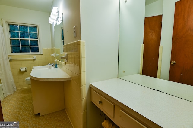 bathroom with vanity and tile walls