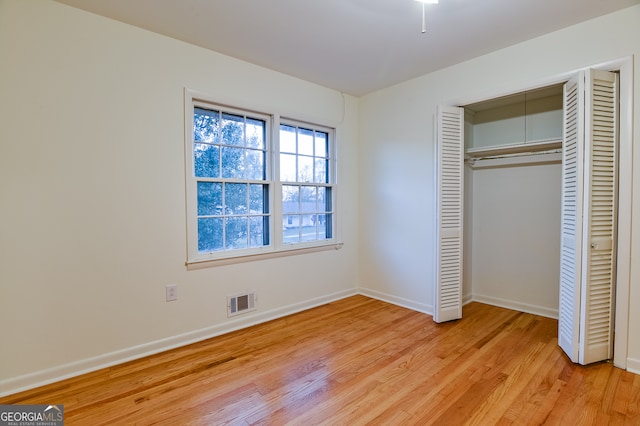 unfurnished bedroom featuring light hardwood / wood-style flooring and a closet