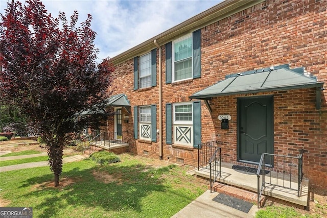 townhome / multi-family property featuring a front yard and brick siding