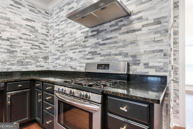 kitchen featuring crown molding, exhaust hood, light hardwood / wood-style flooring, dark stone countertops, and stainless steel range with gas cooktop