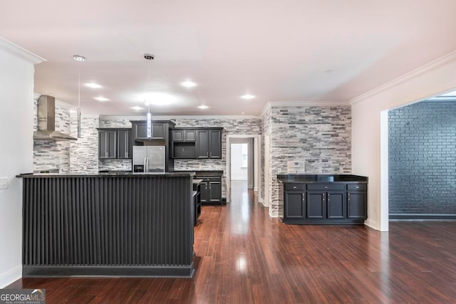 kitchen with wall chimney exhaust hood, stainless steel fridge, dark hardwood / wood-style flooring, and crown molding