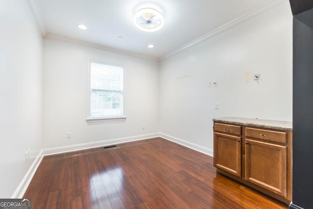 spare room featuring dark hardwood / wood-style flooring and crown molding