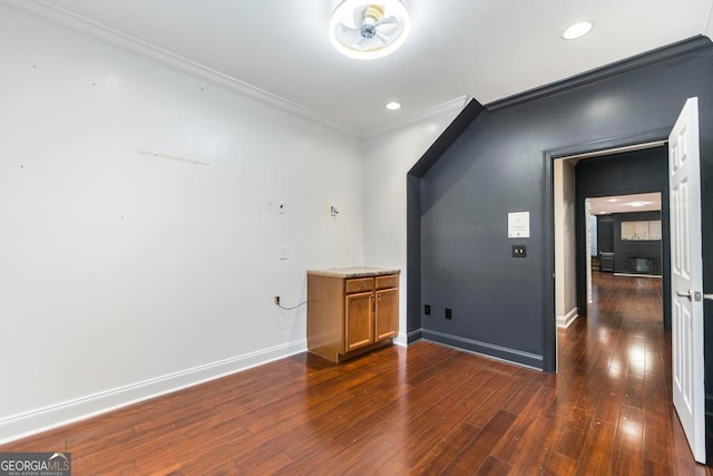 spare room featuring dark wood-type flooring and ornamental molding