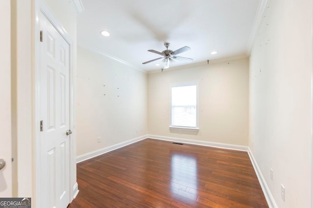 unfurnished room featuring ceiling fan, dark wood-type flooring, and ornamental molding