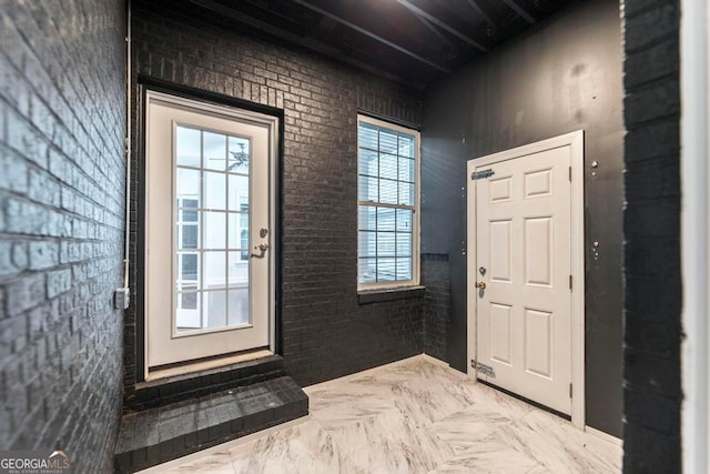 entrance foyer featuring plenty of natural light and brick wall