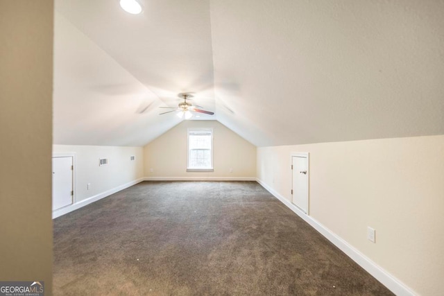 additional living space with dark carpet, ceiling fan, and lofted ceiling