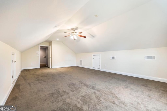 additional living space featuring dark colored carpet, vaulted ceiling, and ceiling fan