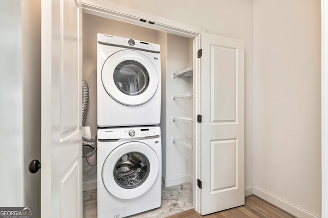 laundry area featuring light hardwood / wood-style floors and stacked washer / dryer