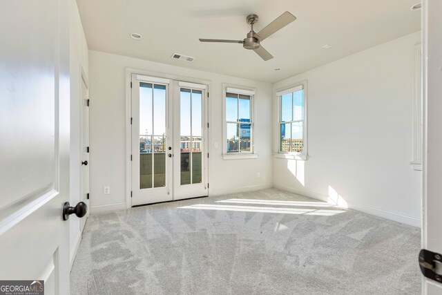 carpeted empty room with ceiling fan and french doors