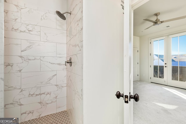 bathroom with a tile shower, ceiling fan, french doors, and a water view