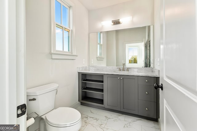 bathroom with vanity, toilet, and a wealth of natural light