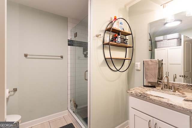 bathroom featuring tile patterned floors, vanity, and a shower with shower door