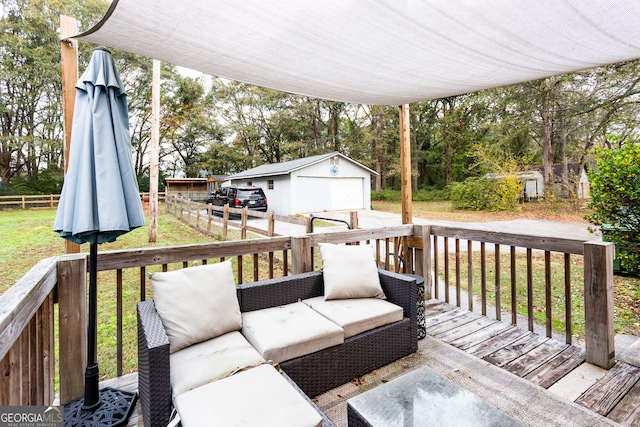 wooden terrace featuring a garage, an outdoor structure, and a lawn