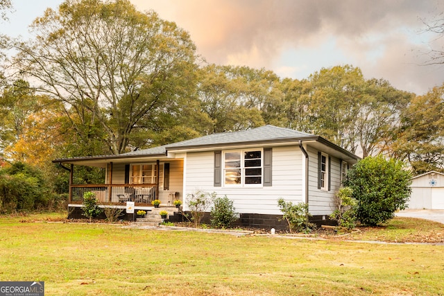 view of front of house featuring an outdoor structure, a garage, a porch, and a front yard