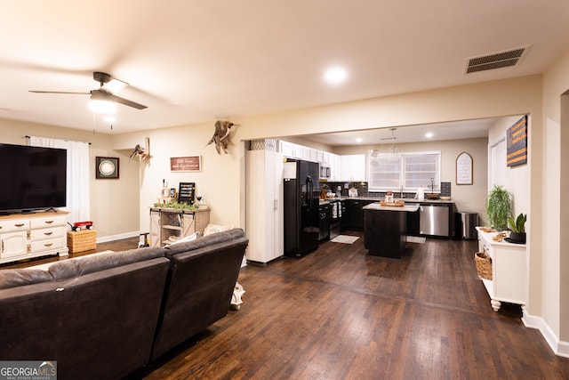 living room featuring ceiling fan and dark wood-type flooring