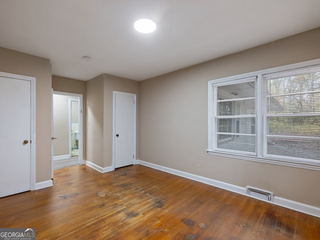 unfurnished bedroom with dark hardwood / wood-style floors