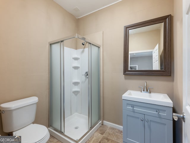 bathroom with tile patterned floors, vanity, toilet, and a shower with shower door