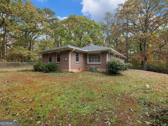 view of side of property featuring a lawn and central AC unit