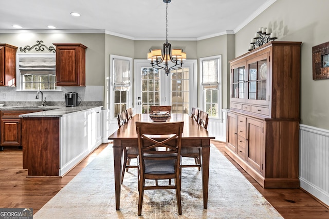 dining space featuring crown molding, hardwood / wood-style floors, and an inviting chandelier