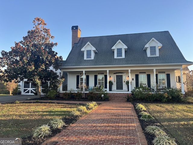 cape cod-style house featuring a front lawn and a porch