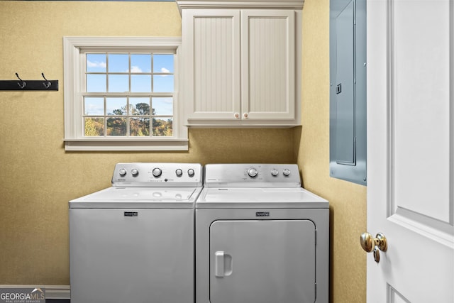 laundry room with cabinets, electric panel, and washer and clothes dryer