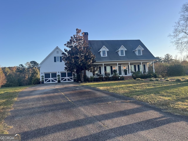 cape cod home featuring a garage, a porch, and a front yard