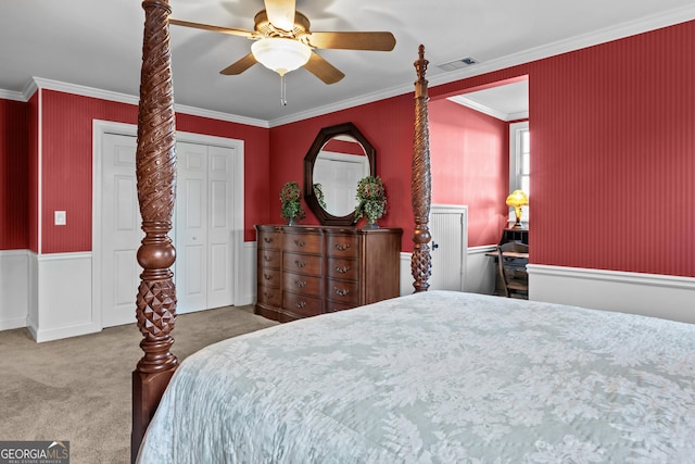 bedroom with crown molding, ceiling fan, a closet, and carpet