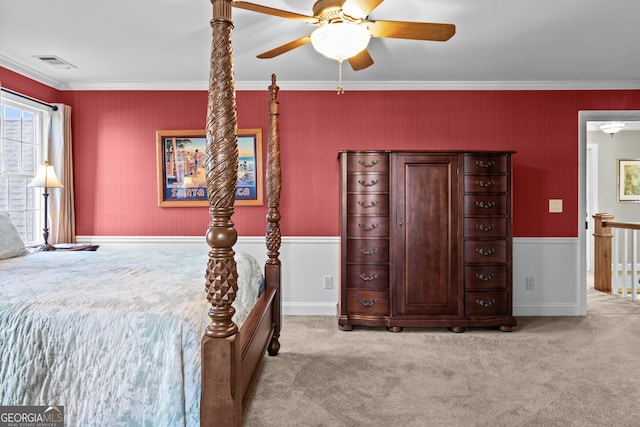 carpeted bedroom featuring crown molding and ceiling fan