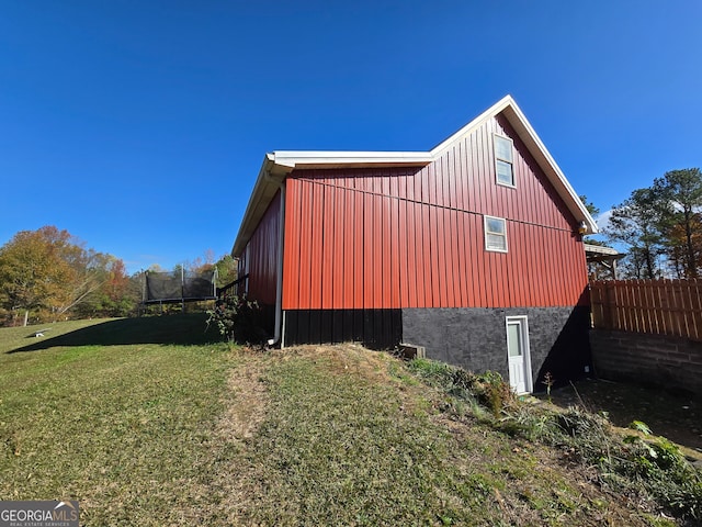 view of property exterior featuring a lawn and a trampoline