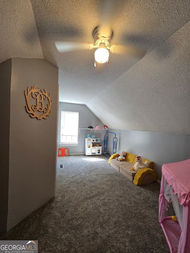 playroom featuring carpet, a textured ceiling, ceiling fan, and lofted ceiling