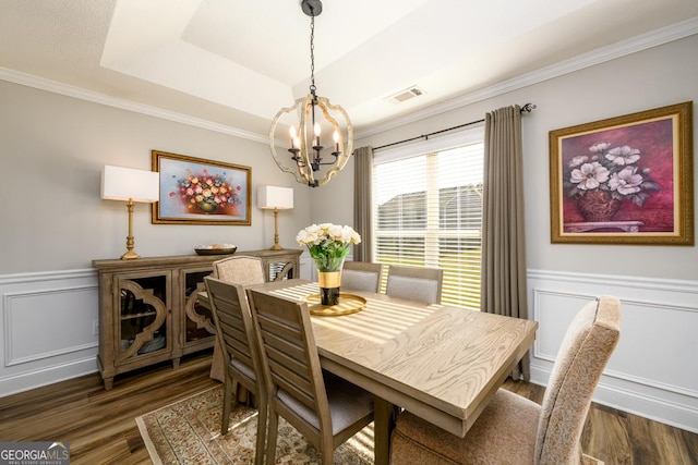 dining room with a chandelier, dark wood-type flooring, and a tray ceiling