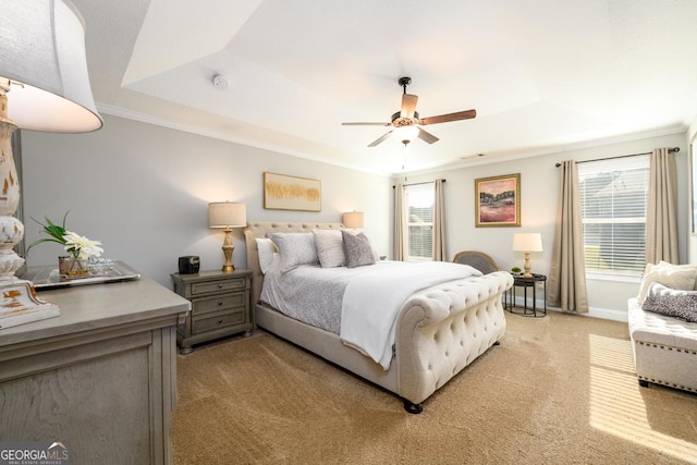 bedroom featuring ornamental molding, light colored carpet, ceiling fan, and a raised ceiling