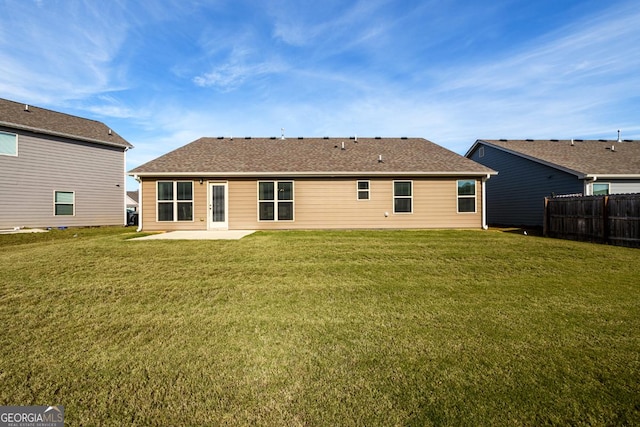 rear view of property featuring a patio and a yard