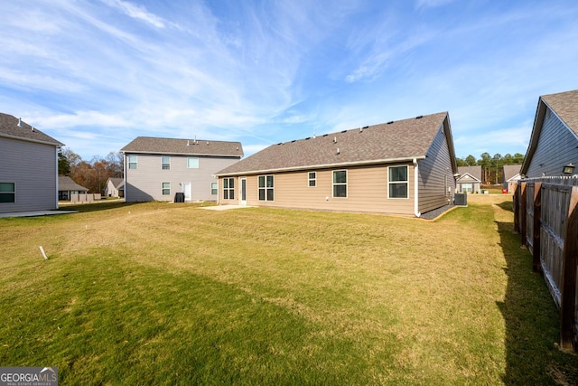 rear view of property with a patio, central AC, and a yard