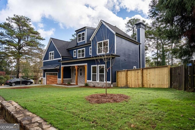 view of front of home featuring covered porch, a front yard, and a garage