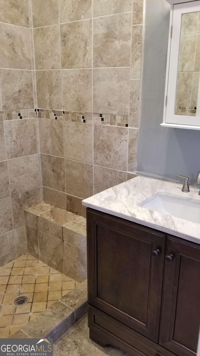 bathroom featuring vanity and tiled shower