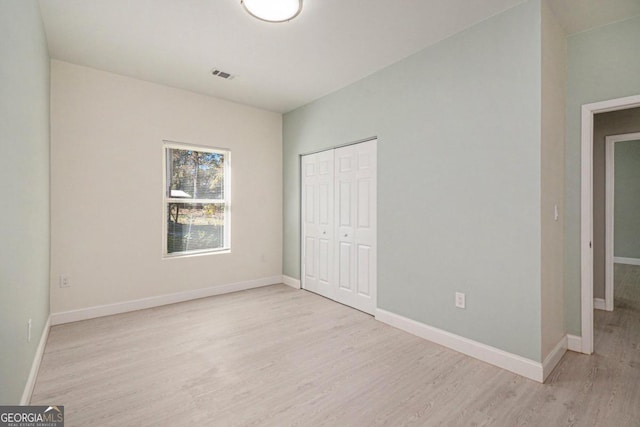 unfurnished bedroom featuring light hardwood / wood-style floors and a closet