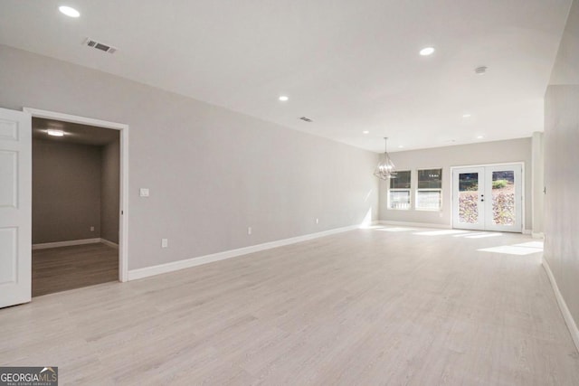 unfurnished living room featuring french doors and light wood-type flooring