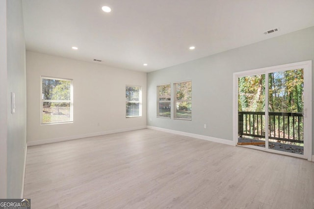 spare room featuring light hardwood / wood-style floors and plenty of natural light