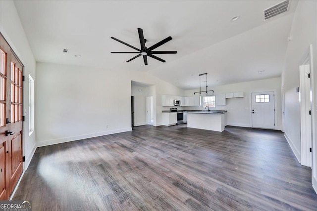 unfurnished living room featuring ceiling fan, dark hardwood / wood-style flooring, vaulted ceiling, and sink