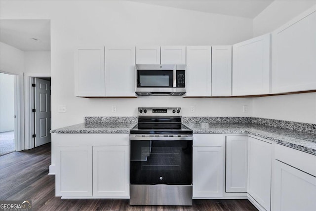 kitchen with appliances with stainless steel finishes, white cabinetry, dark wood-type flooring, and light stone counters