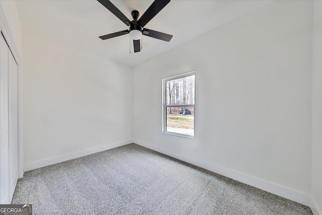 carpeted spare room featuring ceiling fan