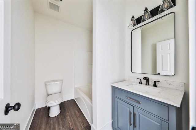 bathroom featuring vanity, hardwood / wood-style flooring, and toilet