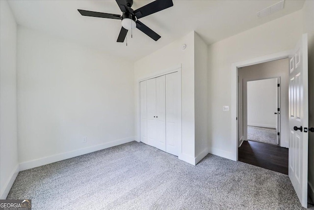 unfurnished bedroom with carpet flooring, ceiling fan, and a closet