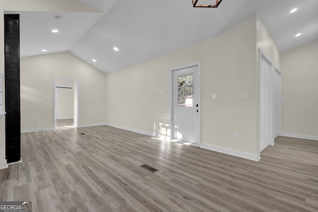 unfurnished living room with light hardwood / wood-style floors and vaulted ceiling