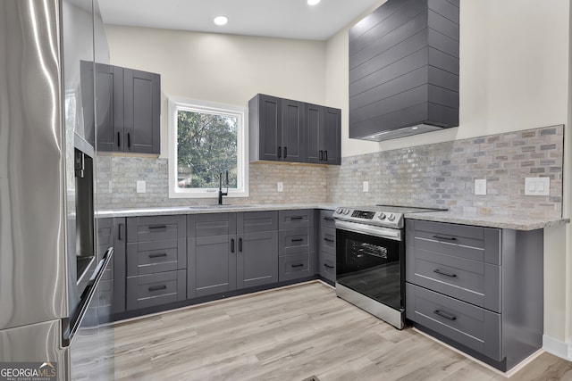 kitchen with appliances with stainless steel finishes, light wood-type flooring, gray cabinetry, and sink