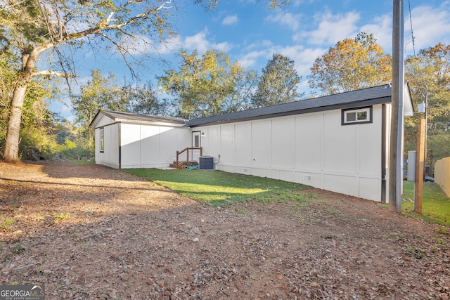 rear view of house with a yard and central AC