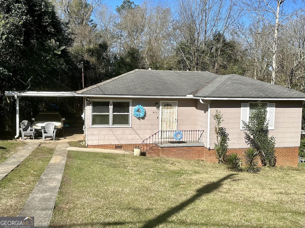 view of front of home featuring a front yard and a carport